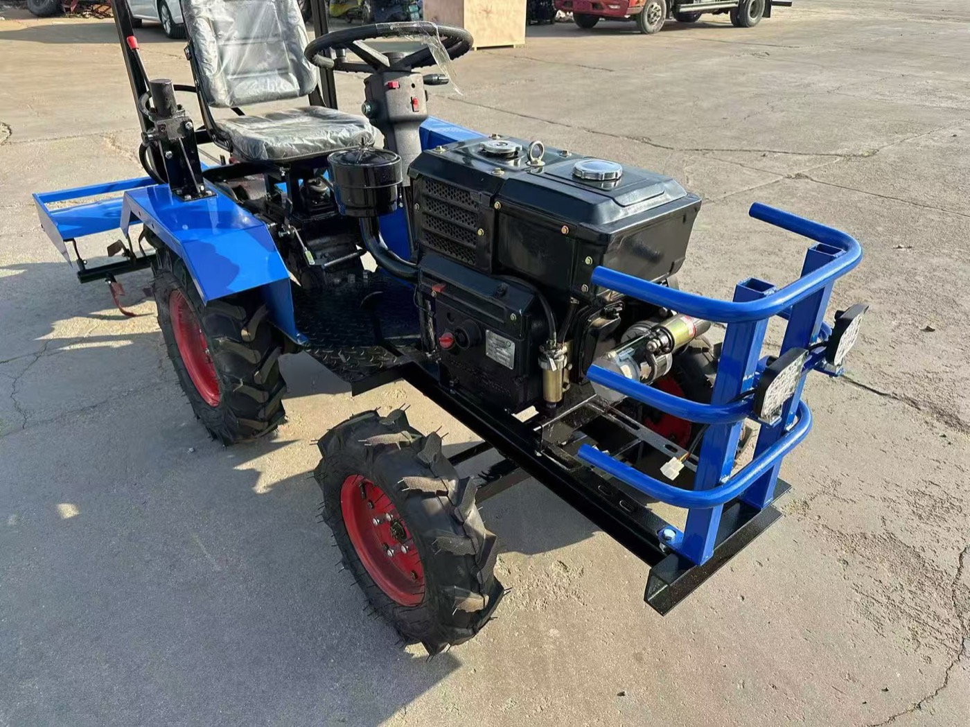 Blue mini tractor front angle showing compact body and farm tires