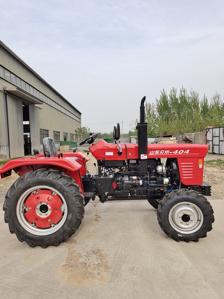 Huaxiang TS404 four-wheel tractor side view in factory yard